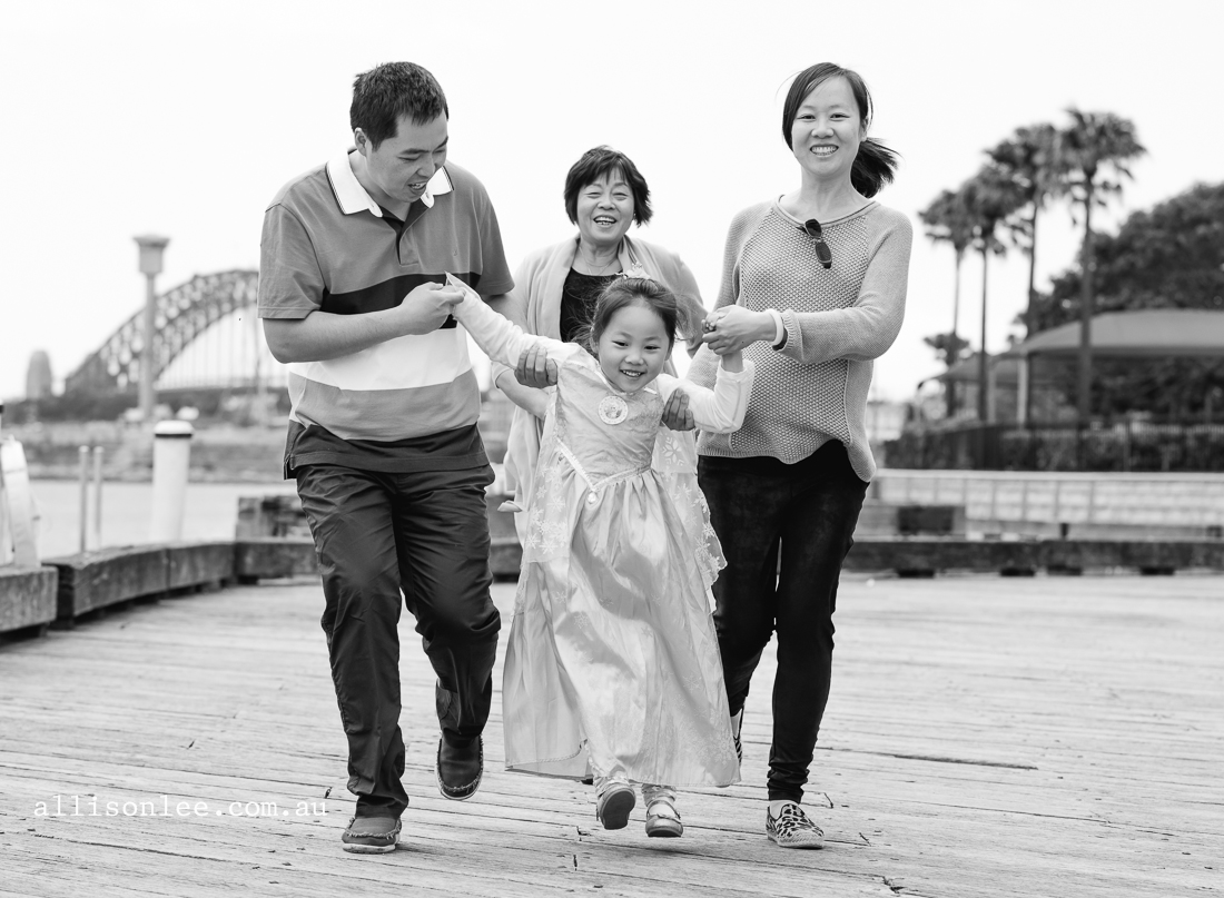 Family playing on wharfs with Harbour Bridge in background
