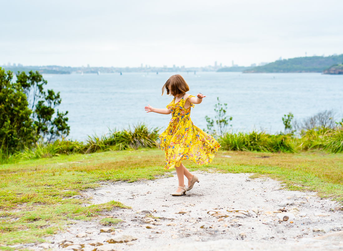 Little girl twirling in Manly over the harbour