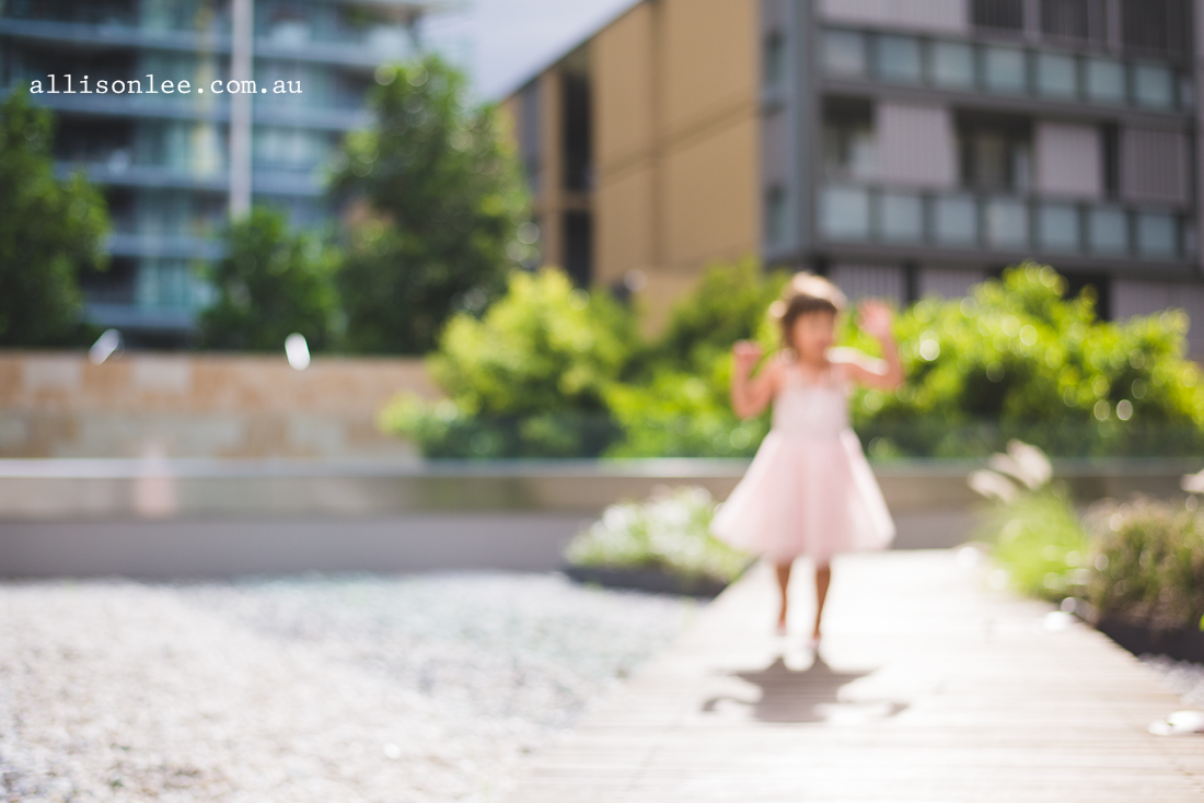 Five year old in pink ballet dress playing in rock garden in Pyrmont